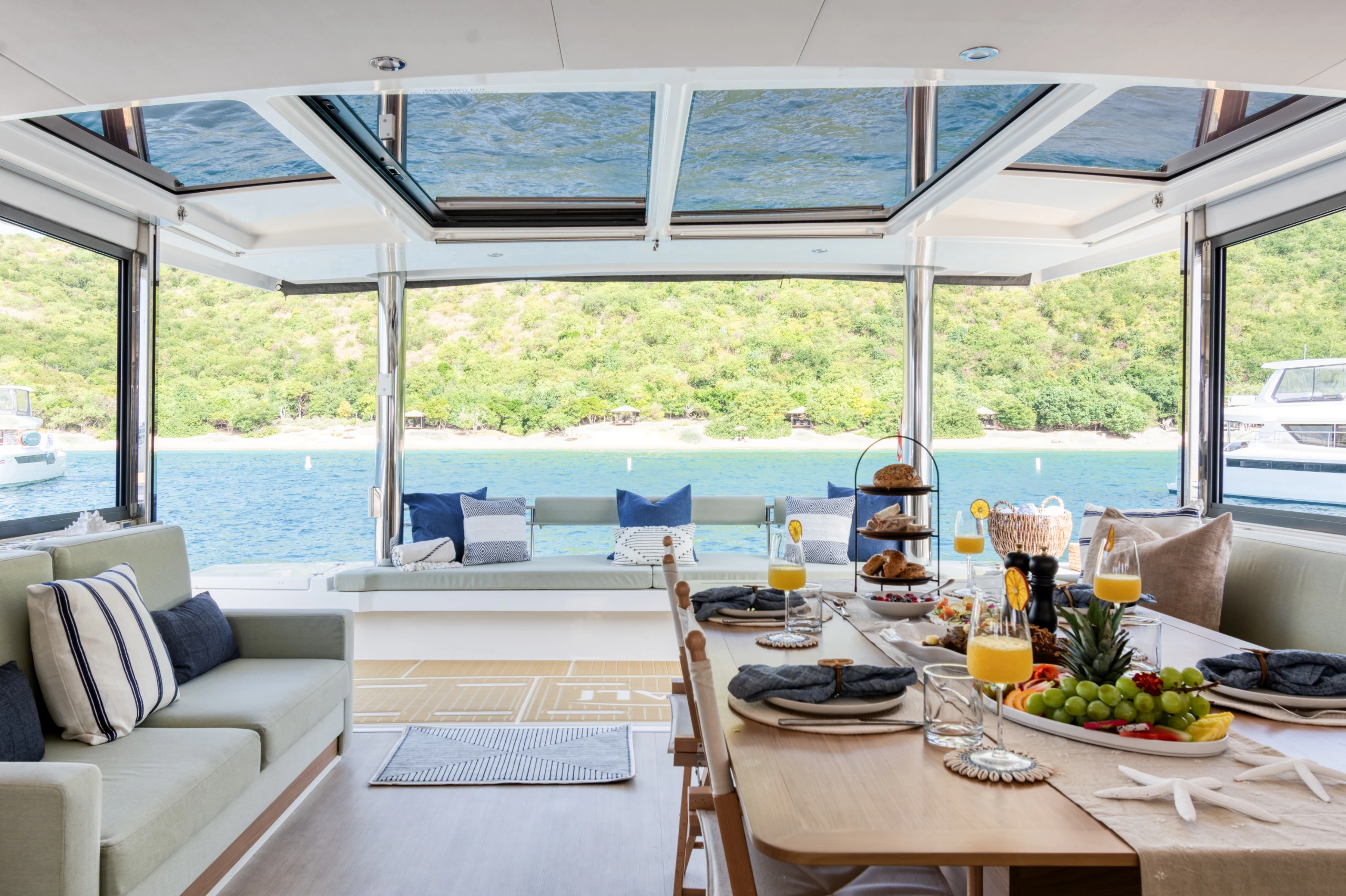 Allegra’s open-plan salon with the dining table set and water views on every side